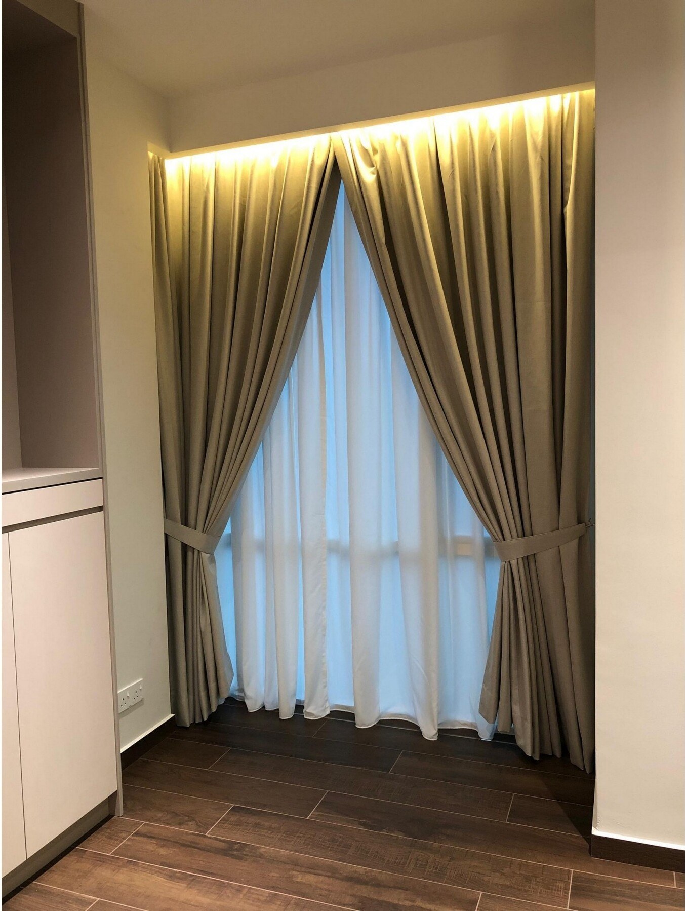 Beige drapery curtains with sheer day-curtains in luxury bedroom