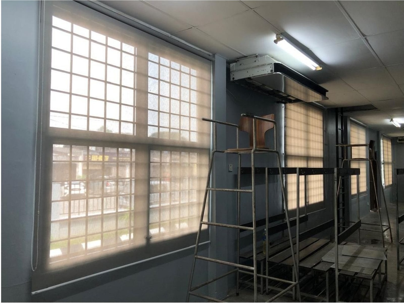 Long row of roller blinds along an industrial Malaysian corridor