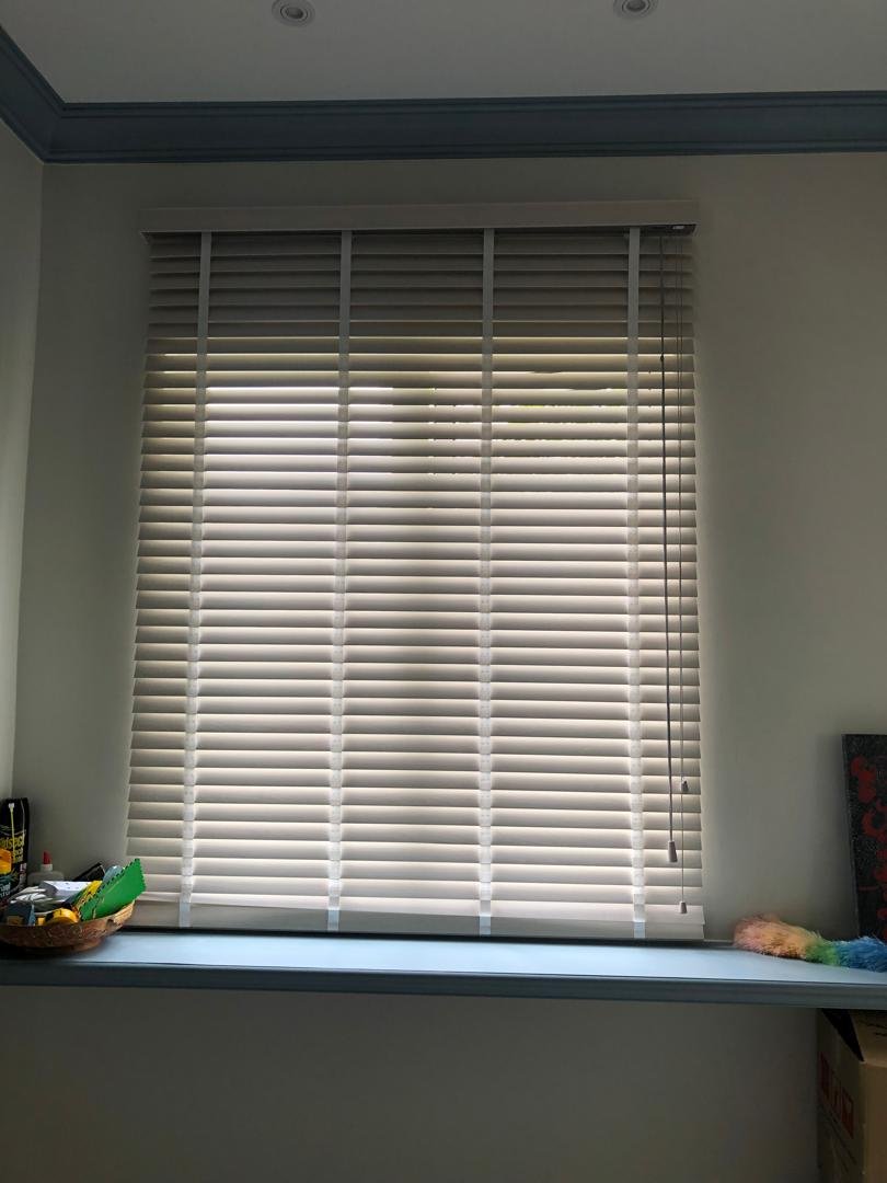 White venetian blinds fully closed for privacy in a Malaysian bay window